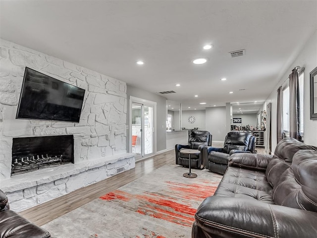 living room with a healthy amount of sunlight, light hardwood / wood-style floors, and a fireplace