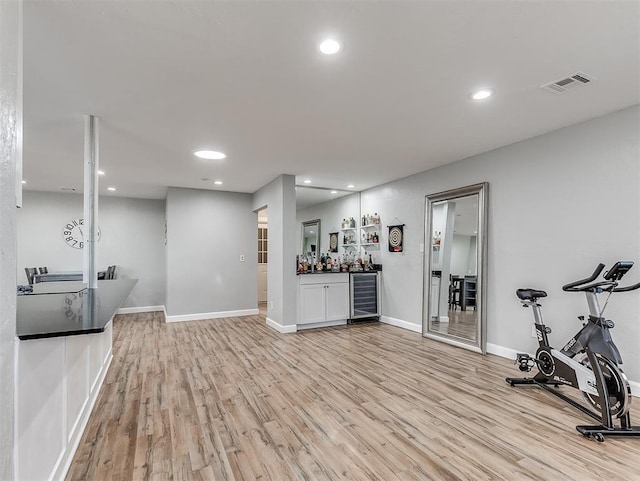 interior space with bar area, light wood-type flooring, and wine cooler