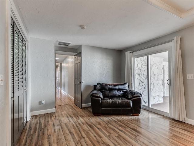 living room featuring ornamental molding and wood-type flooring