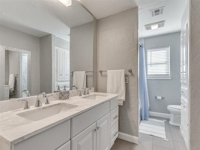 bathroom with toilet, tile patterned floors, and vanity