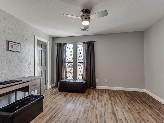 sitting room with a textured ceiling, light hardwood / wood-style flooring, and ceiling fan