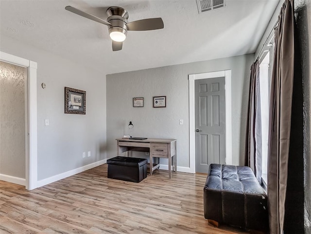 living area with light hardwood / wood-style floors and ceiling fan