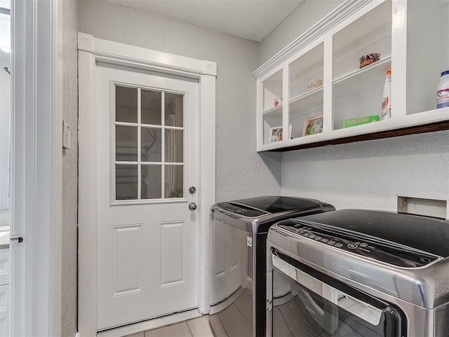 laundry room featuring washer and clothes dryer and tile patterned floors