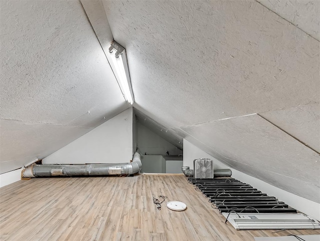 bonus room with hardwood / wood-style flooring and vaulted ceiling