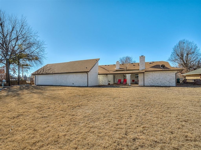 back of house featuring a yard and a garage