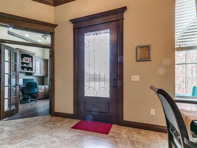 foyer entrance featuring baseboards and french doors