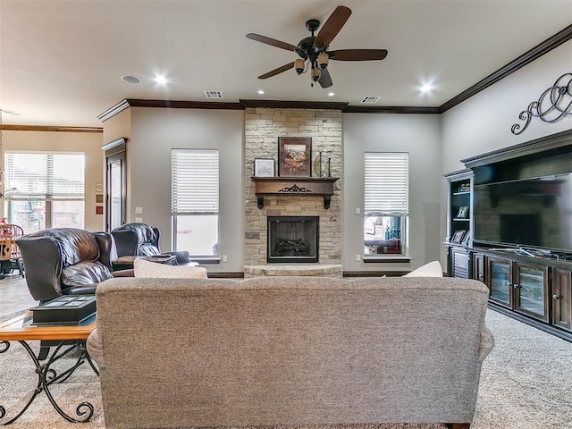 living area with ceiling fan, ornamental molding, a fireplace, and visible vents