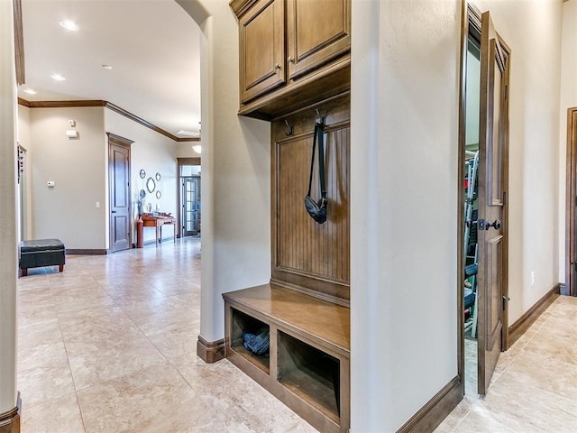 mudroom featuring crown molding and light tile patterned floors