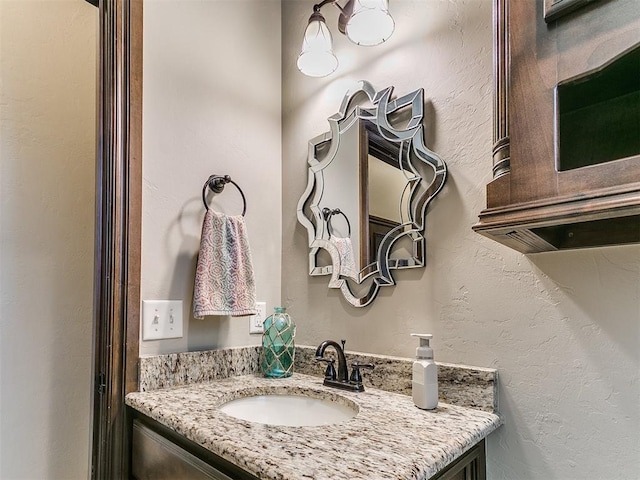 bathroom with a textured wall and vanity