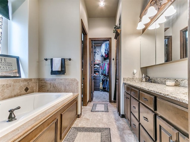 full bath featuring a spacious closet, vanity, and a bath