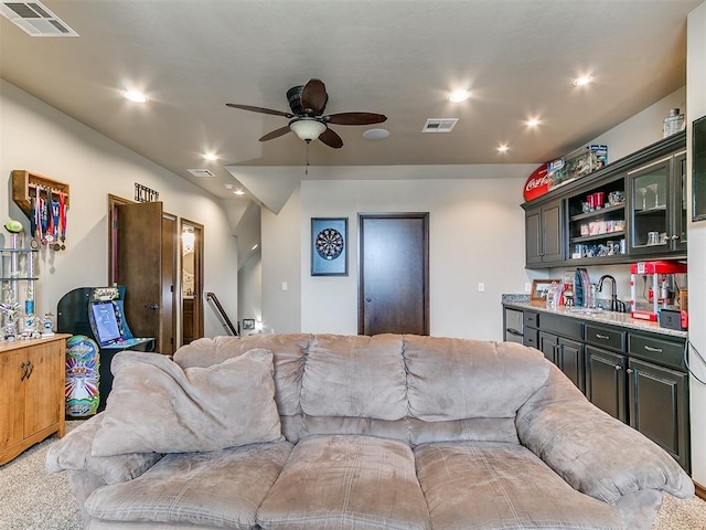 living room with wet bar, ceiling fan, and carpet