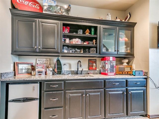 bar featuring stainless steel refrigerator and sink