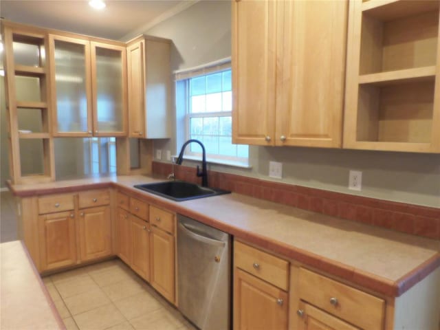 kitchen featuring light tile patterned floors, dishwasher, light brown cabinets, and sink