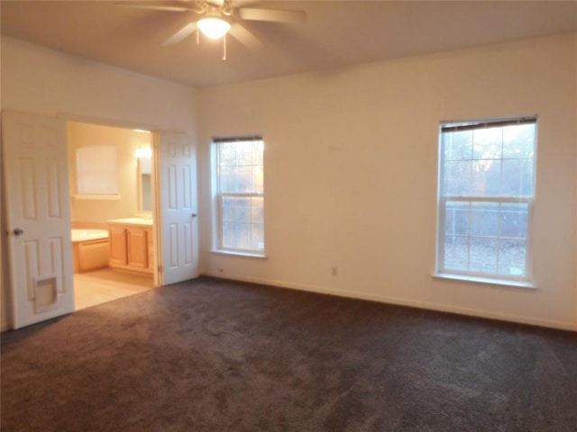 unfurnished bedroom with ceiling fan, carpet flooring, and connected bathroom