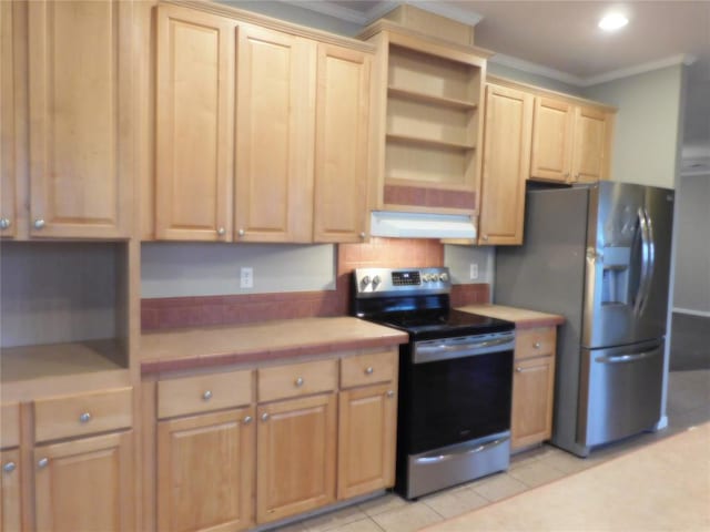 kitchen featuring tile counters, appliances with stainless steel finishes, crown molding, and light tile patterned flooring