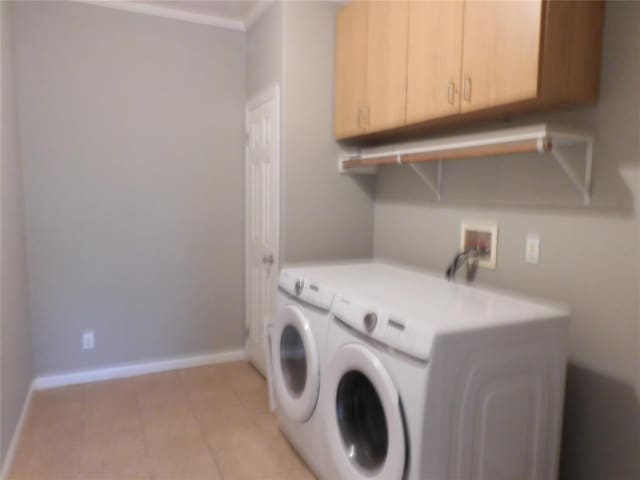 laundry area with light tile patterned flooring, cabinets, ornamental molding, and washing machine and clothes dryer