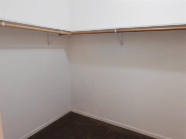 spacious closet featuring dark carpet