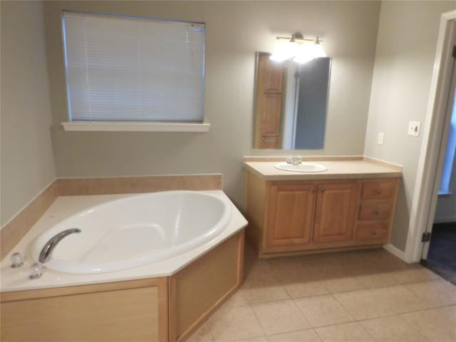 bathroom featuring a tub to relax in, vanity, and tile patterned flooring