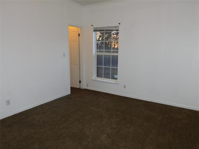 spare room featuring dark colored carpet