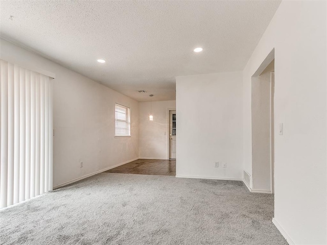 empty room featuring carpet flooring and a textured ceiling