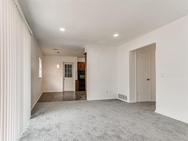 carpeted spare room with a textured ceiling