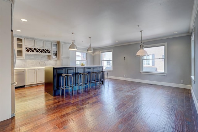 kitchen featuring pendant lighting, a kitchen breakfast bar, backsplash, and a kitchen island