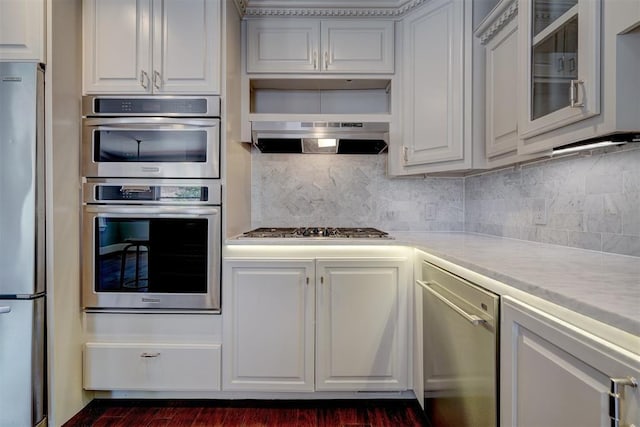 kitchen featuring backsplash, white cabinetry, light stone countertops, and appliances with stainless steel finishes