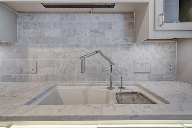 kitchen with sink, backsplash, and light stone countertops