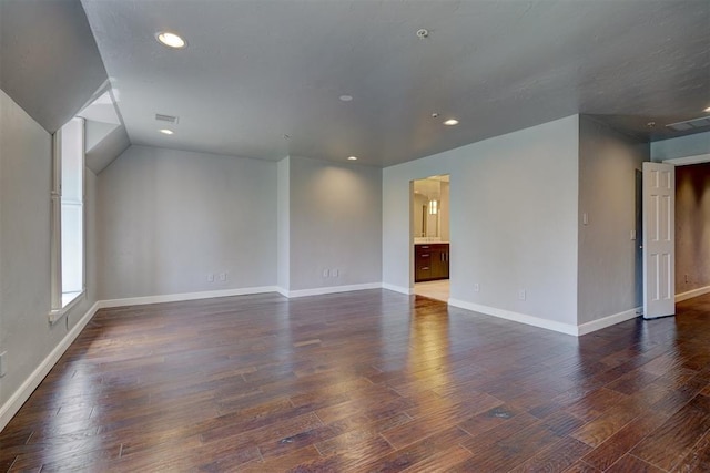 unfurnished room featuring dark hardwood / wood-style floors and lofted ceiling