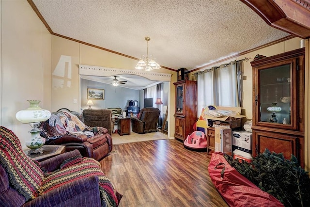 living room featuring hardwood / wood-style floors, ceiling fan with notable chandelier, lofted ceiling, crown molding, and a textured ceiling