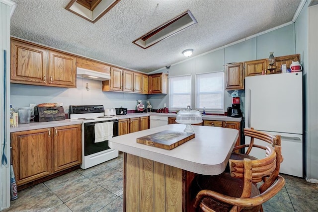 kitchen featuring lofted ceiling, white appliances, a breakfast bar area, a textured ceiling, and a kitchen island