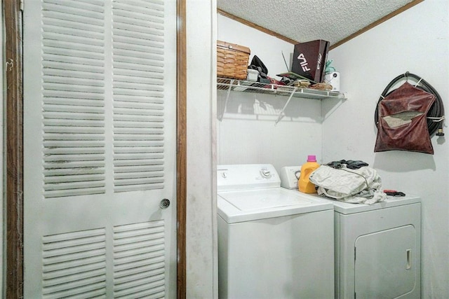 washroom with crown molding, washing machine and dryer, and a textured ceiling