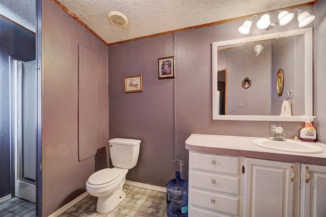 bathroom with vanity, crown molding, a textured ceiling, and toilet