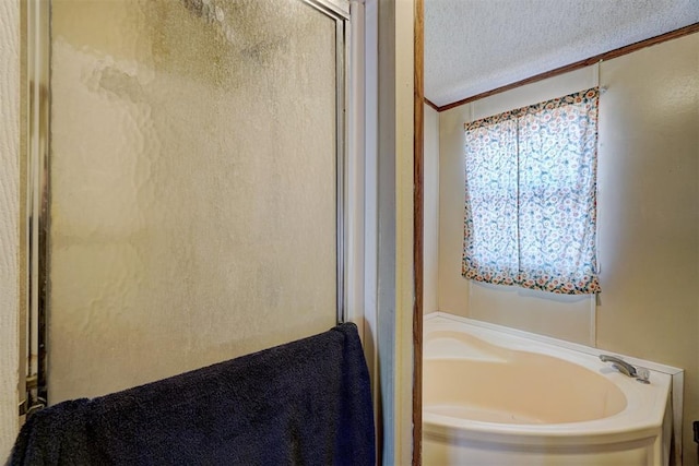 bathroom with independent shower and bath and a textured ceiling