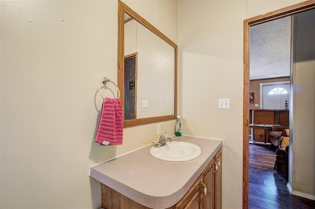 bathroom featuring vanity, hardwood / wood-style flooring, and a textured ceiling