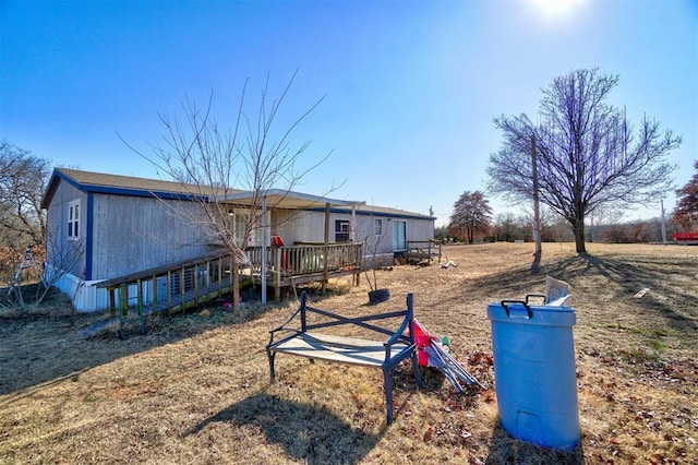 rear view of property featuring a wooden deck