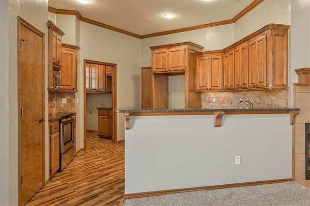 kitchen featuring dark stone countertops, ornamental molding, and a kitchen breakfast bar