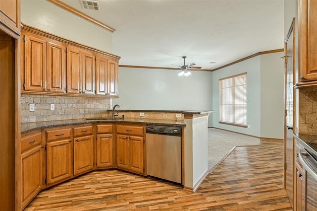 kitchen with tasteful backsplash, dishwasher, sink, kitchen peninsula, and light hardwood / wood-style flooring