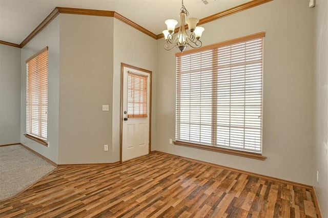 empty room with an inviting chandelier, hardwood / wood-style floors, plenty of natural light, and ornamental molding