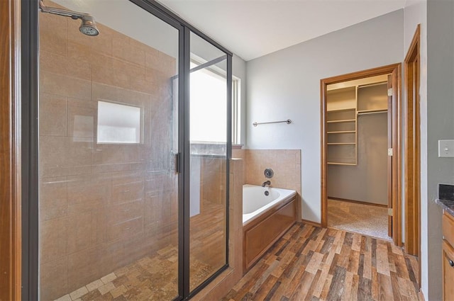 bathroom featuring hardwood / wood-style flooring, vanity, and shower with separate bathtub