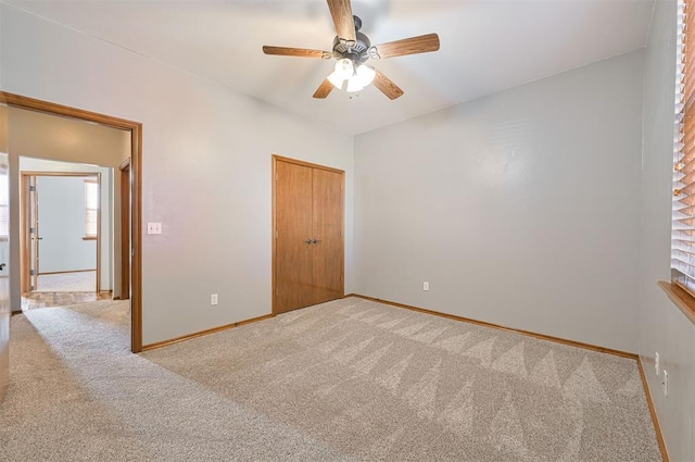 unfurnished bedroom with light colored carpet, ceiling fan, and a closet