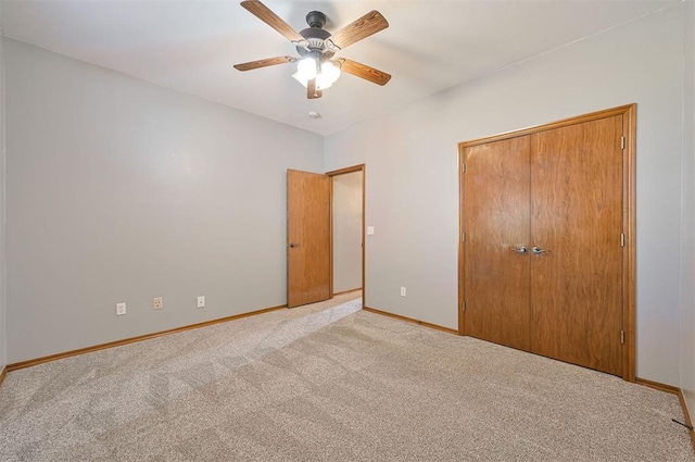 unfurnished bedroom with light carpet, a closet, and ceiling fan