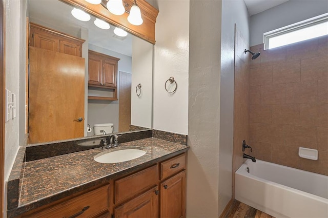 full bathroom with vanity, toilet, and tiled shower / bath combo