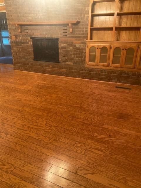 unfurnished living room with hardwood / wood-style flooring and a fireplace