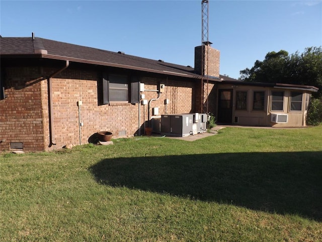 back of property featuring cooling unit and a yard