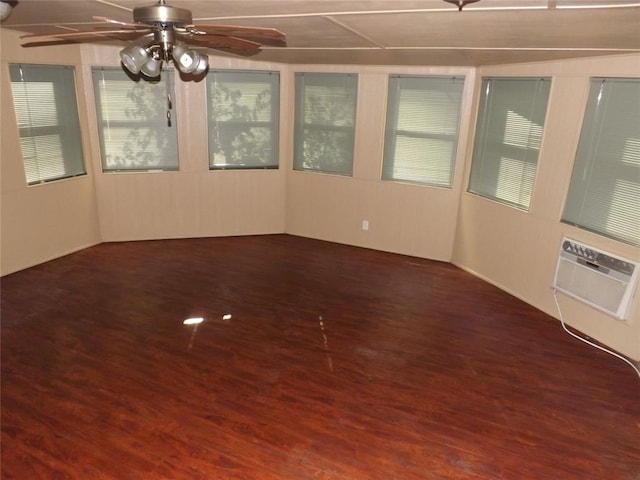 unfurnished sunroom with ceiling fan and a wall mounted air conditioner