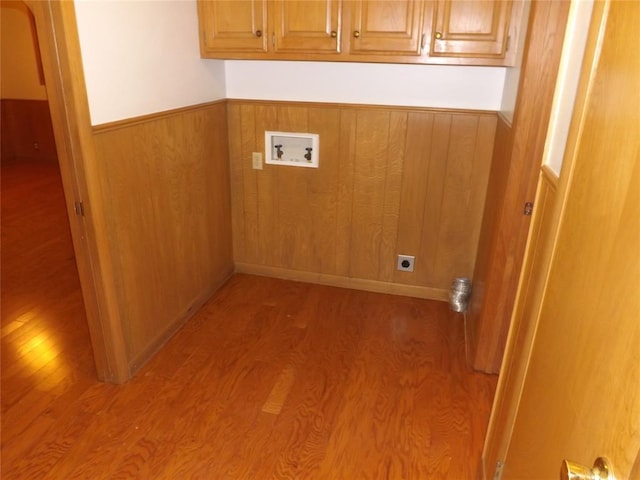 clothes washing area with cabinets, washer hookup, electric dryer hookup, and light wood-type flooring