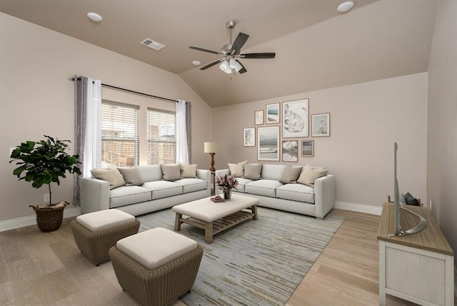 living room with ceiling fan, light hardwood / wood-style flooring, and vaulted ceiling