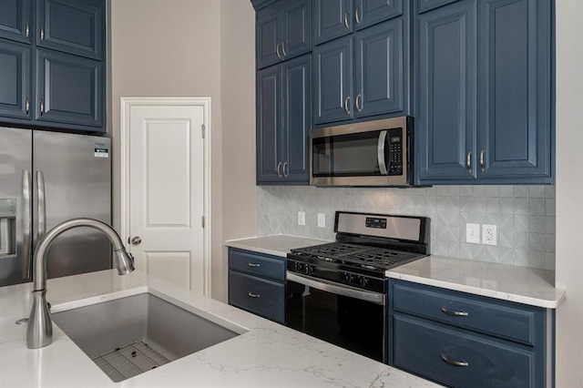 kitchen featuring decorative backsplash, sink, appliances with stainless steel finishes, and blue cabinets