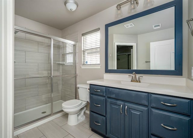 bathroom featuring vanity, toilet, tile patterned floors, and a shower with door